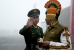 A Chinese soldier gestures while standing alongside an Indian soldier