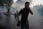 Thai anti-government protesters flee tear gas. Photo by AFP.