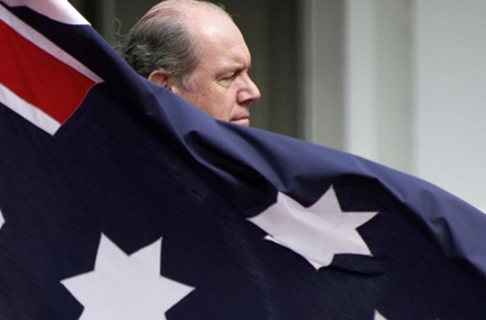 Defence Minister David Johnston stands behind an Australian flag - and the navy. Photo by AFP.
