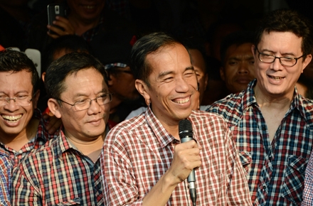 Jokowi with checkered shirt and microphone. Photo by AFP.
